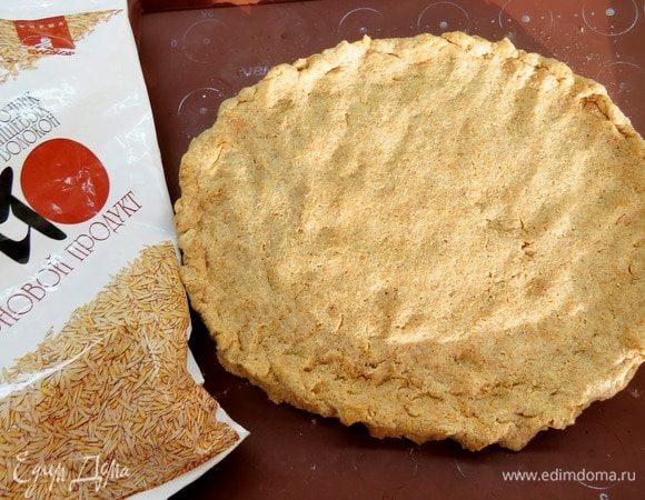 Тесто выложить на силиконовый коврик или бумагу для выпечки в виде круга диаметром 20–22 см, разровнять, сделать небольшие бортики по краям.