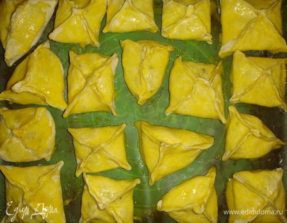 Выкладываем слоечки на противень, застеленный пергаментом и смазываем их взбитым с водой желтком. Выпекаем в разогретой до 180°С духовке 25–30 минут.