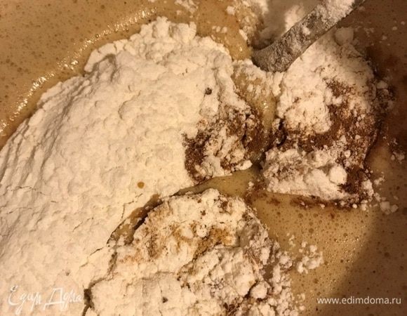 В несколько этапов добавить муку, соединенную с молотыми специями и разрыхлителем.