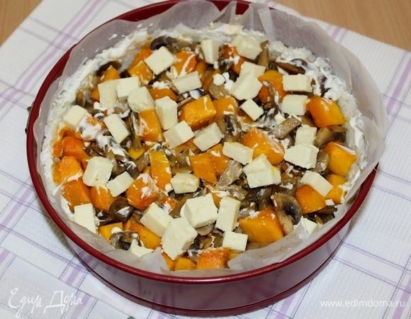 Затем достаньте, смажьте рис сверху сметаной, на начинку покрошите сыр и выпекайте пирог еще 10 минут.