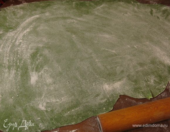 Берем половину теста, нагреваем его руками, чуть покатав, перед раскатыванием тесто должно быть комнатной температуры. На припыленной мукой поверхности раскатываем тонко.