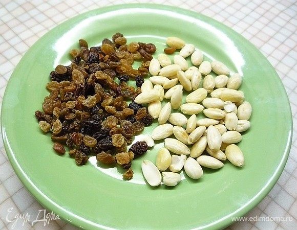 Изюм промываем и просушиваем, миндаль заливаем кипятком на 15 минут, очищаем, просушиваем на сковороде и нарезаем маленькими кусочками.