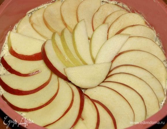 Тесто перекладываем в форму, разравниваем. Украшаем дольками яблока. 