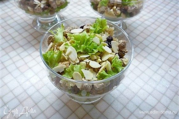 Заправляем салат заправкой, посыпаем листиками салата и лепестками миндаля.