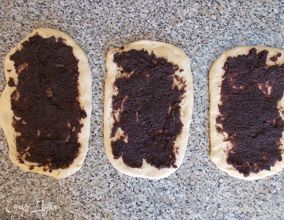 Затем берем  маковую начинку. Я использую уже готовую маковую начинку с шоколадом. Это намного упрощает и ускоряет процесс приготовления. Готовая начинка по форме напоминает небольшую «колбаску». Делаем небольшой надрез (примерно 1–1,5 см) у основания маковой «колбаски» и выдавливаем из нее маковую начинку сразу на подготовленное тесто. С помощью силиконовой лопатки (или ножа, ложки) равномерно  размазываем начинку по тесту. Количество начинки зависит от вашего вкуса. Можно использовать всю начинку из «колбаски», можно половину. Я взяла половину. 