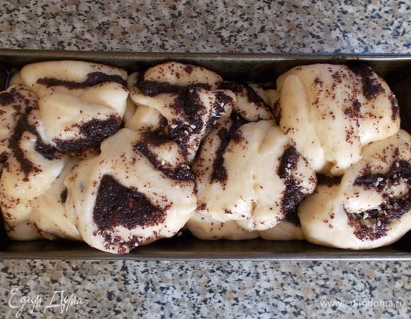 Когда наш хлебец поднимется и полностью заполнит форму, смазываем его взбитым желтком и посыпаем кунжутом или орехами. Выпекаем 40 минут в разогретой до 180°С духовке.