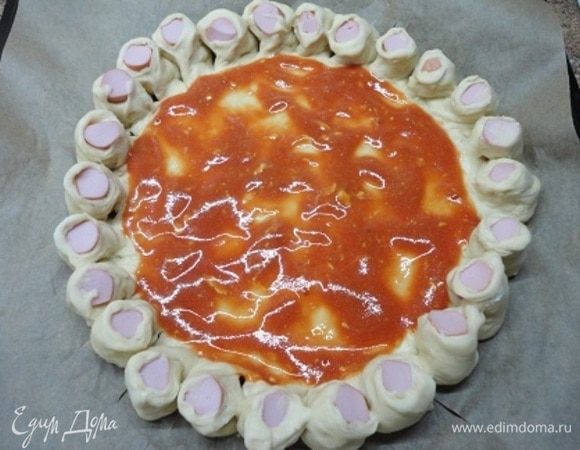 Бортики разрежьте по размеру сосисок и выверните срезом вверх.  Середину смажьте томатным соусом, смешанным с горчицей.