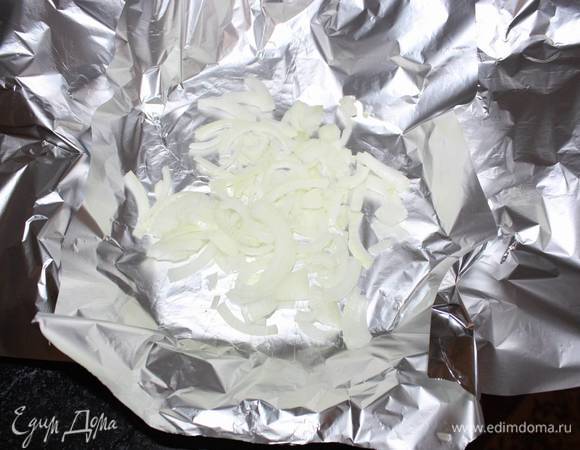 В фольгу первым слоем выкладываем часть лука. 