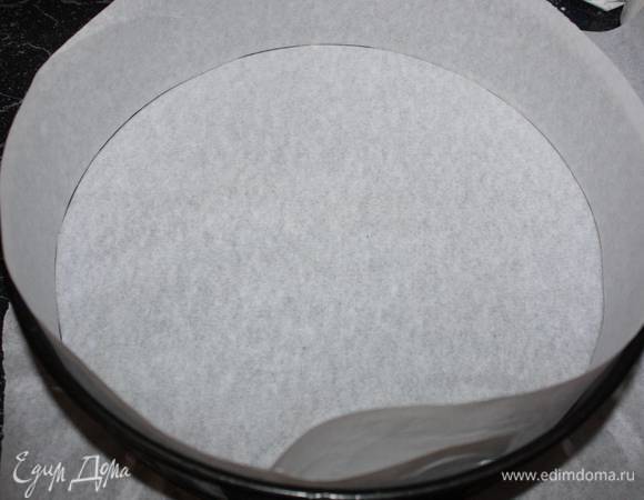 Выкладываем половину теста в разъемную форму (в данном случае диаметр формы 26 см), выстланную пергаментной бумагой.