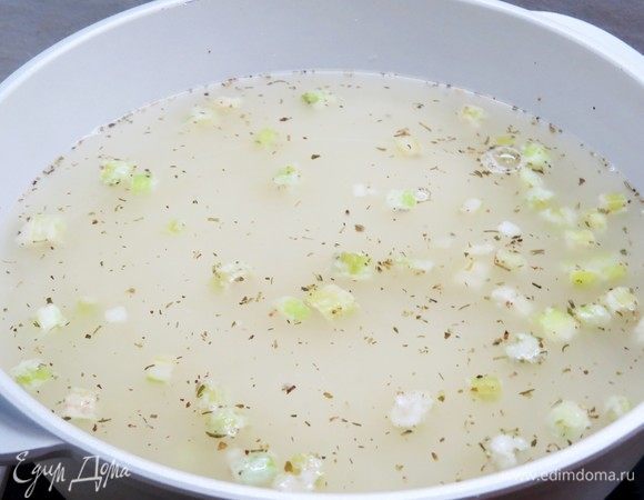 Вливаем в кастрюлю с овощами 2,5 литра куриного бульона, даем супу закипеть, затем уменьшаем огонь до малого.