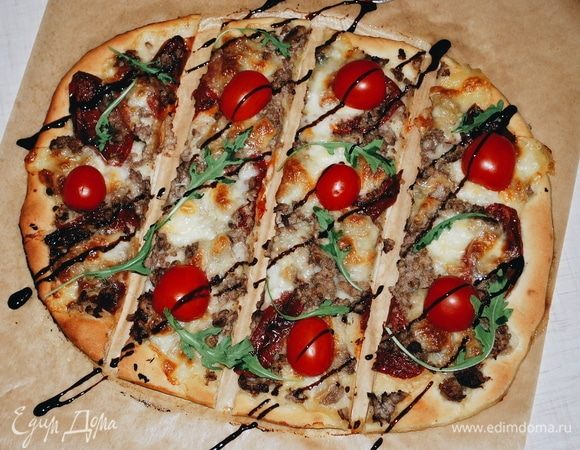 Готовую пиццу поливаем бальзамическим соусом и выкладываем помидоры черри.