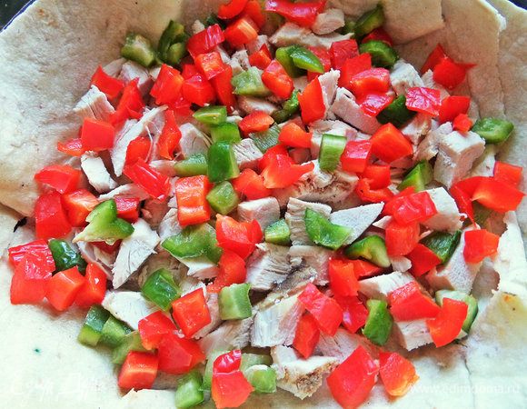 На дно лавашной тарелки насыпать курочку и перцы.