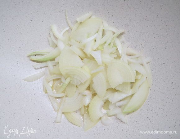 Репчатый лук нарезаем четверть-кольцами. Разогреваем сковороду с оливковым маслом, обжариваем лук до золотистого цвета. 