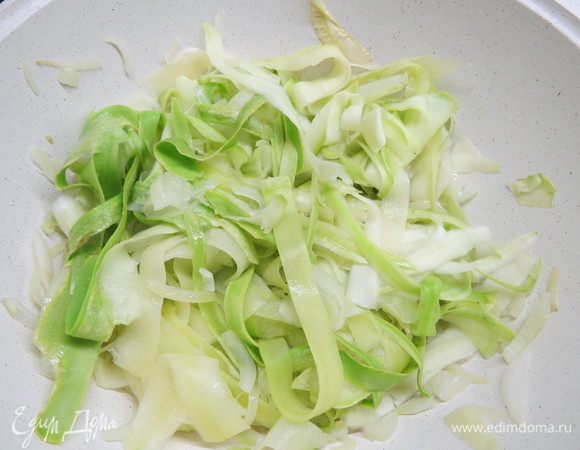 К луку добавляем нарезанные полосками кабачки, солим по вкусу, тушим овощи 5–7 минут. Кабачки должны уменьшиться в объеме примерно в 2 раза. 