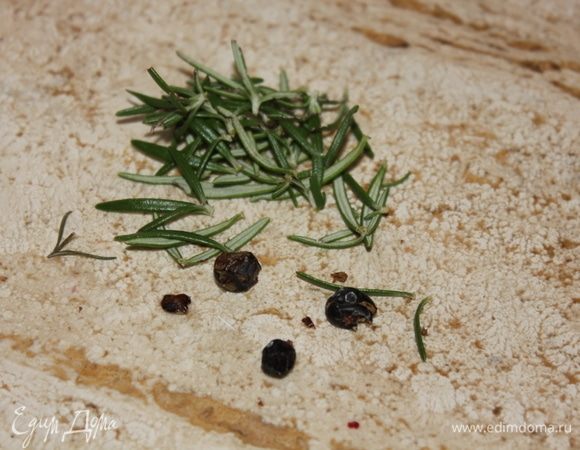 Тем временем, раздавить плоской частью ножа ягоды можжевельника, отделить листья от веточки розмарина.