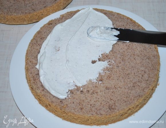 Остывший бисквит разрежем на две части. Нанесем часть крема.