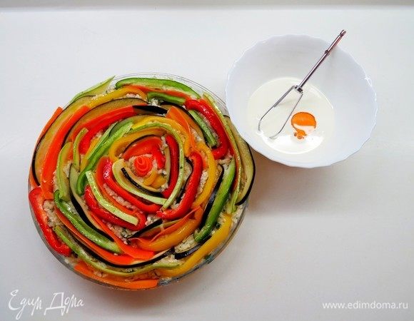 Сливки взбить с яйцом и с помощью ложечки влить смесь между всех овощей.