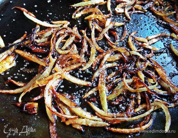 Когда хорошо зажарится, влить соевый соус и добавить коричневый сахар. Еще держать на огне до хруста лука, и пока соус не испарится.