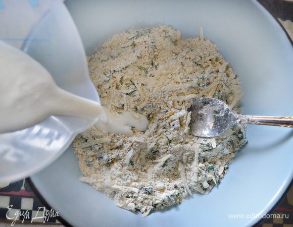 К муке постепенно добавляйте масло и перетрите в крошку. Затем соедините с сыром, цедрой лимона и зеленью, влейте кефир и вымесите тесто.