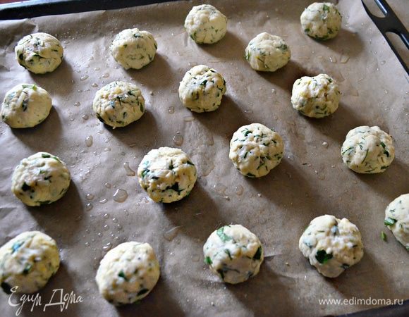 Руками отделяйте небольшие кусочки теста и сформируйте шарики, размером чуть больше грецкого ореха. Из данного количества ингредиентов у меня получилось 18 шт. Выложите заготовки на противень, выстланный пергаментом и слегка смазанный маслом.