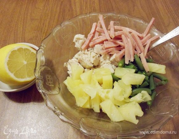 В салатнике замариновать в лимонном соке филе курицы, ветчину, ананас и предварительно отваренную в течение 1 минуты фасоль.