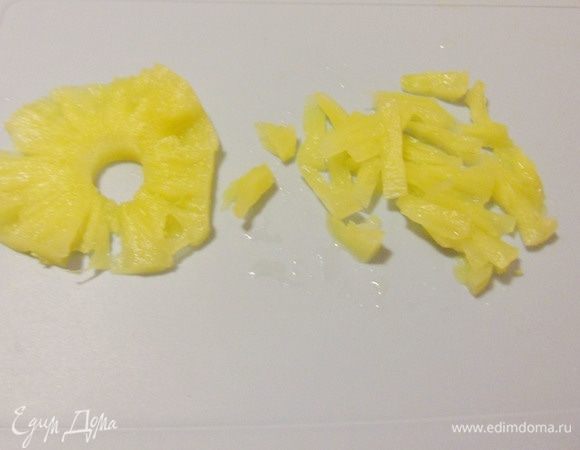 Кольца консервированного ананаса нарезать мелкими кусочками.