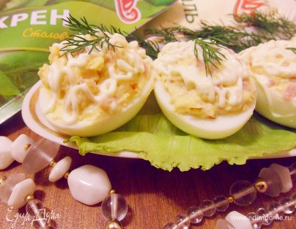 Украсить зеленью по вкусу. Яйца фаршированные ветчиной и хреном готовы.