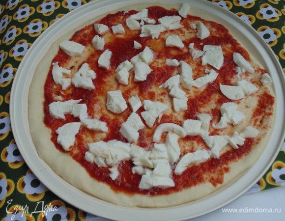 Моцареллу порезать небольшими кусочками. Смазать соусом пиццу, выложить моцареллу. Выпекать 10 минут.