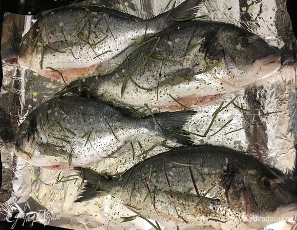 Рыбу солим, перчим, приправляем розмарином, поливаем соком лимона и отправляем в духовку, разогретую до 180°С, на 30 минут.