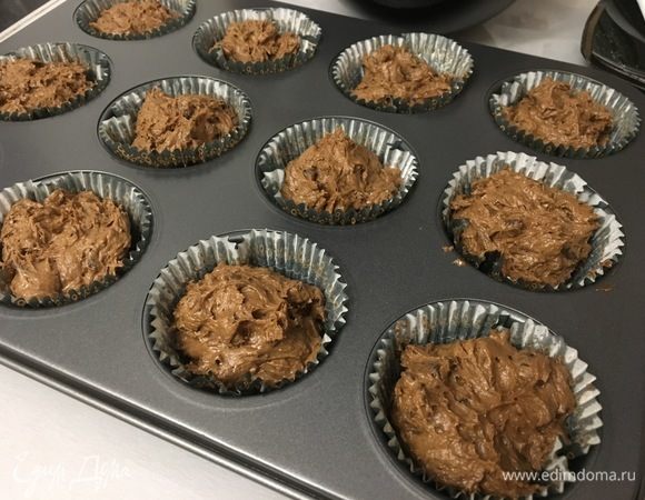 Формочки для запекания смазываем сливочным маслом и выкладываем готовое тесто так, чтобы оно заняло больше половины места. Убираем в духовку, разогретую до 180°С, на 25 минут.