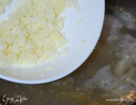 Сваренный крупный картофель мнем и кладем обратно в бульон.