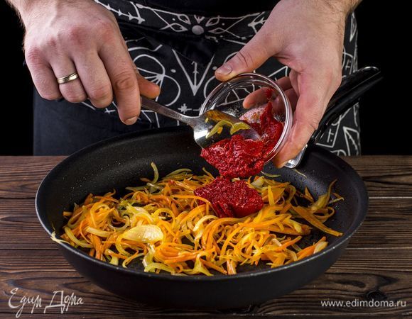 Обжарьте лук и морковь на оливковом масле до мягкости. Добавьте томатную пасту. Все хорошо перемешайте и тушите в течение 4 минут, помешивая.