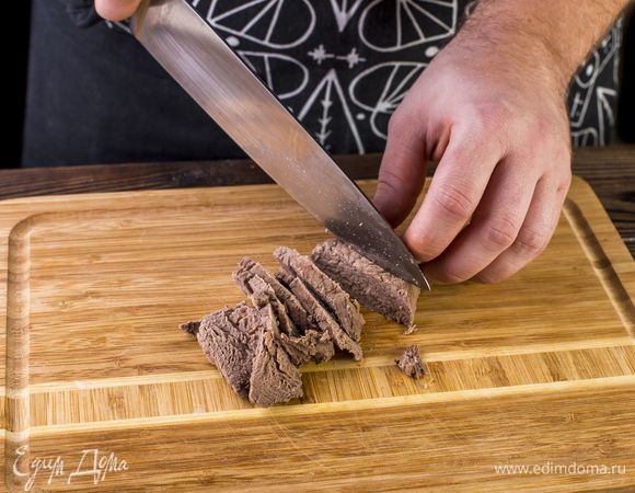 Готовое мясо выньте из бульона, остудите и нарежьте кусочками. 