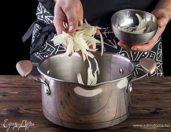 Креветки и мидии разморозьте и хорошо промойте. Слейте жидкость. Лук очистите и нарежьте полукольцами. В кастрюлю с толстым дном налейте оливкового масла. Выложите лук.