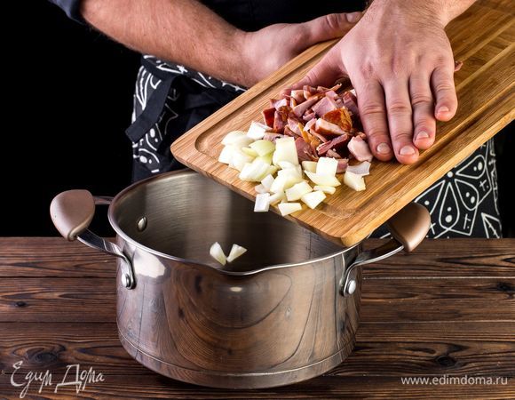 В кастрюле с толстым дном или глубоком сотейнике поджарьте на оливковом масле лук и мясо в течение 5 минут.