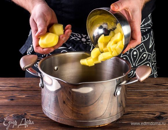 Добавьте в сотейник картофель измельченный и 2 очищенных целых.