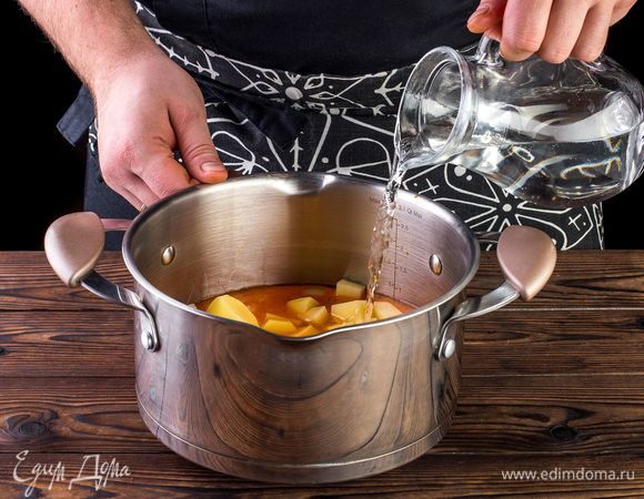 Влейте немного воды, чтобы жидкость слегка покрывала остальные ингредиенты. Варите на среднем огне до готовности картофеля.