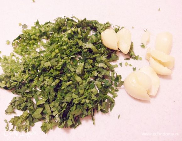 Зелень петрушки нашинковать, дольки чеснока размять ножом.