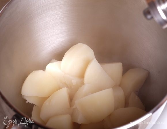 Приготовить картофельное пюре с луковыми чипсами. Для этого картофель почистить, разрезать пополам, отварить в подсоленой воде до готовности (варить примерно 20–25 минут). Воду слить.