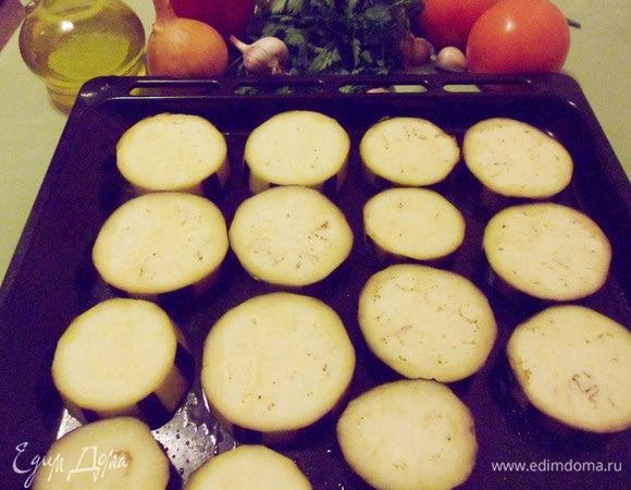 Противень смазать оливковым маслом, выложить баклажаны, посолить и поставить в разогретую до 150°С духовку на 20 минут. 