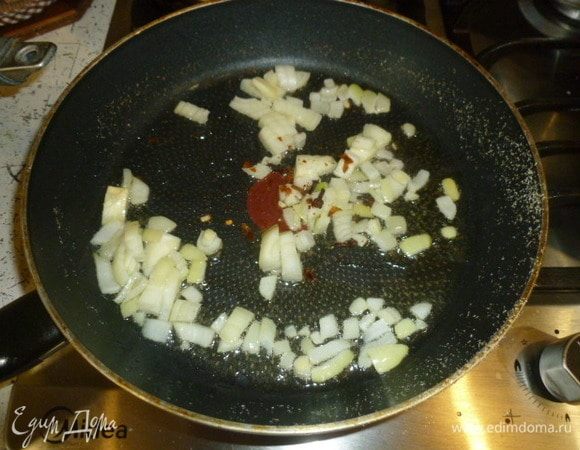 Лук мелко нарезать. Сковороду вернуть на огонь, плеснуть масло, пассеровать лук и раскрошенный чили со щепоткой соли и гвоздикой.