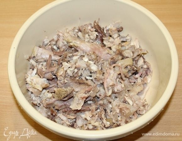 Измельчить мясо на разные по размеру кусочки, так они будут красивее смотреться на разрезе. Добавить немного бульона, в котором варилось мясо, выдавить зубчик чеснока. Все перемешать.