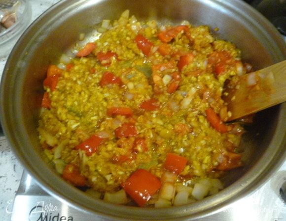 Второй перец и лук нарезать кубиками. В большом сотейнике разогреть оставшееся масло, обжарить лук и перец, добавить томатную пасту, уксус. Обжарить.