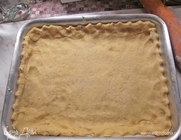 Первое тесто достать из холодильника и раскатать по размеру формы + небольшие бортики. У меня 30x40 см. На дно формы положить лист пекарской бумаги.