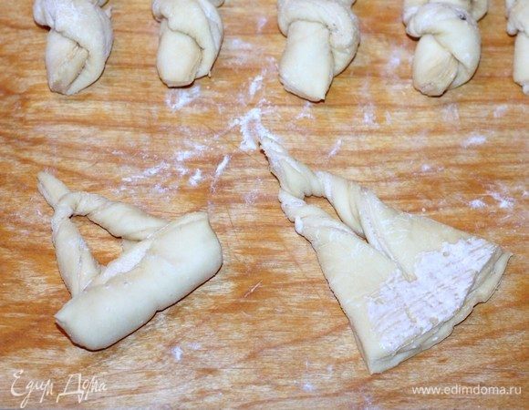 Затем смазываем широкую часть лепестка начинкой и закручиваем тесто, как рогалик.
