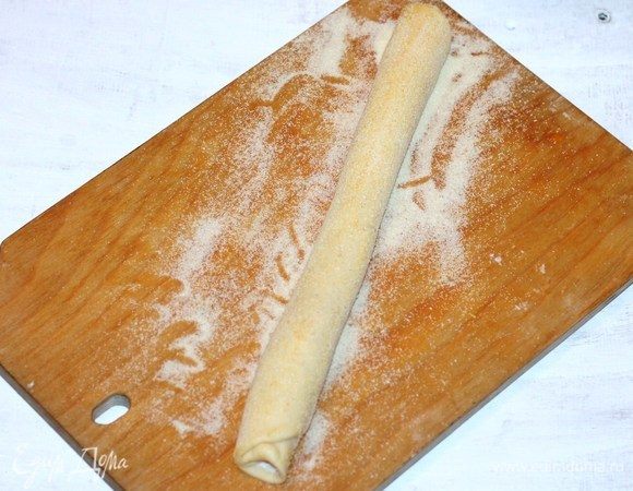 Скатываем прямоугольный пласт в рулет, длиной ~ 35-40 см, так чтобы хватило выложить в формочке круг. Смазываем верх рулета взбитым желтком с 1 ст. л. молока, и обваливаем в манной крупе или панировочных сухарях. 