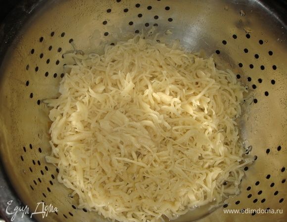 Вскипятить 1,5 литра воды. Половину лапши сложить в дуршлаг, потрясти, чтобы убрать излишки муки и ошпарить кипятком.