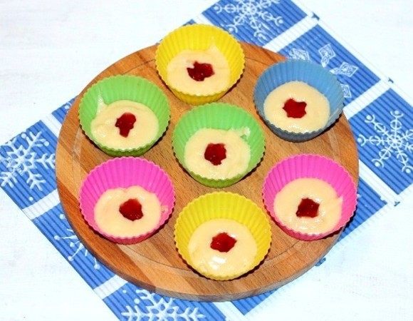 Полученную смесь по 1 ч. л. с горкой раскладываем по силиконовым формочкам. Формочки не смазываем маслом. Затем кладем по 1 ч. л. малинового джема ТМ «МахеевЪ». 
