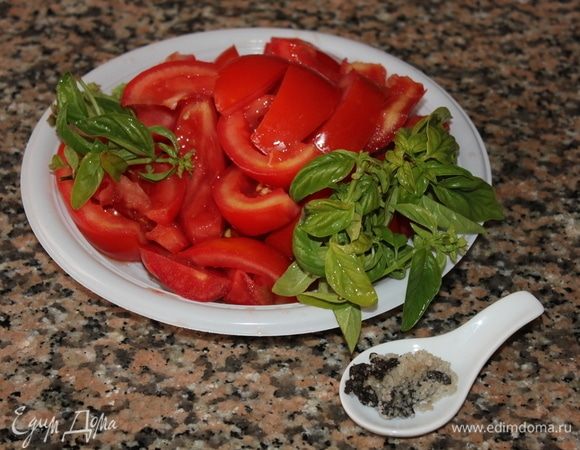 Тем временем подготовить веточки базилика и нарезать помидоры продольными дольками.