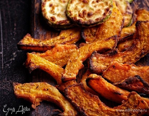 Духовку разогреть до 220°С. Ломтики тыквы сбрызнуть оливковым маслом, посыпать итальянскими травами, можно слегка посолить и посахарить (по желанию) и разложить в 1 слой на противне, застеленном бумагой для выпечки. Если есть камень для выпечки — идеально, тогда тыква получится идеально пропеченной с двух сторон.